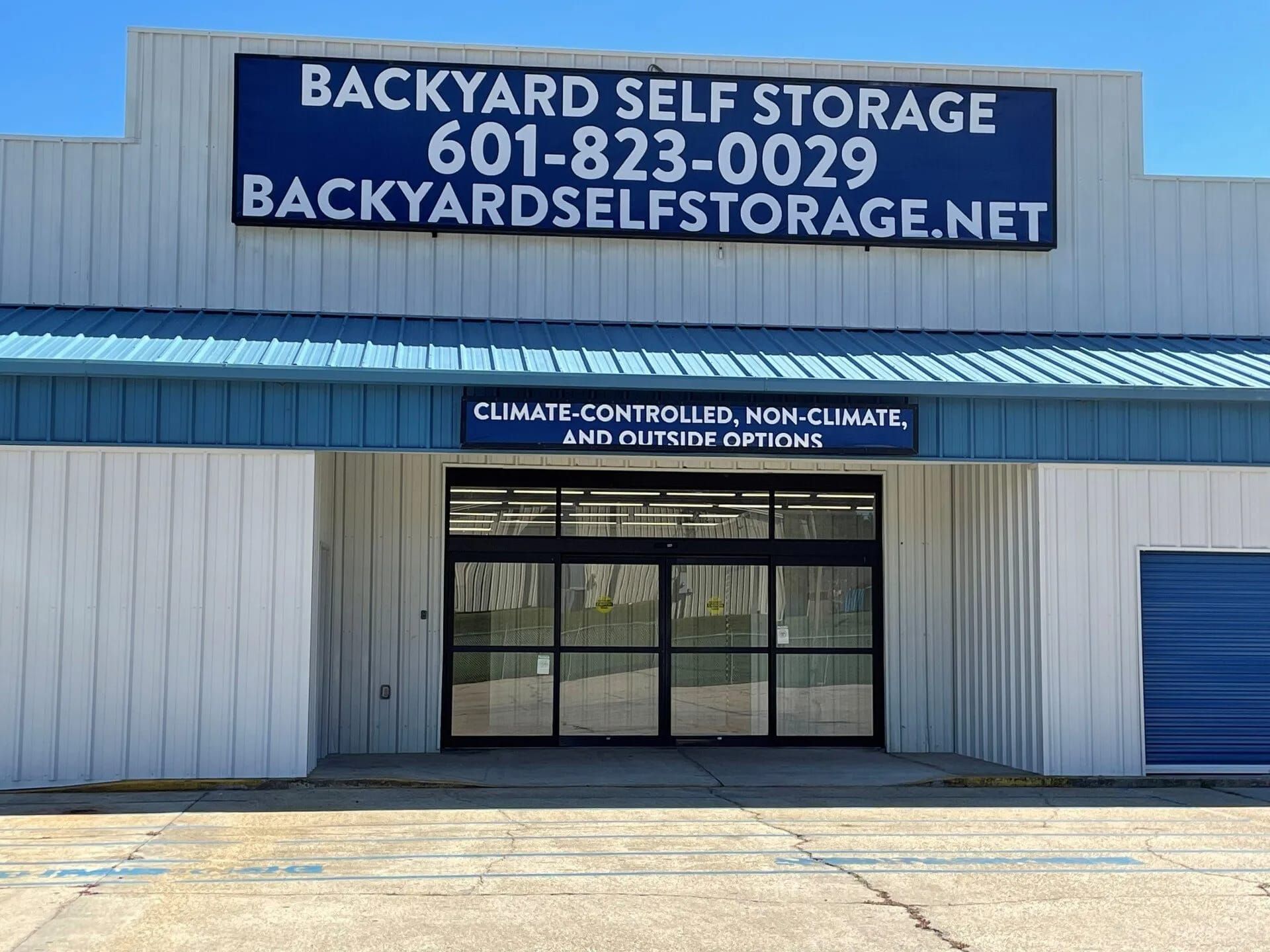 Backyard Self Storage building with blue and white signage, phone number, and website address.