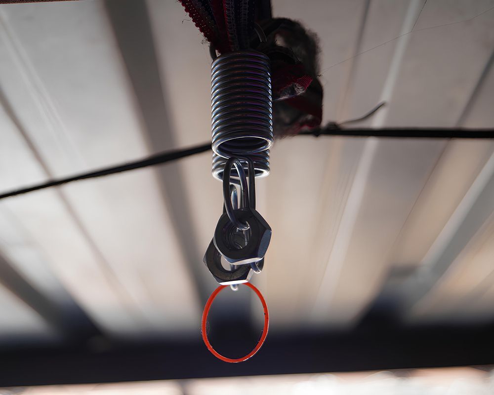 A close up of a spring with a red ring attached to it.