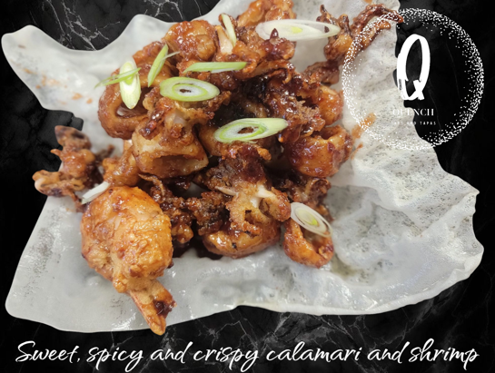 Sweet and spicy crispy calamari and shrimp, garnished with green onions, on a patterned plate.