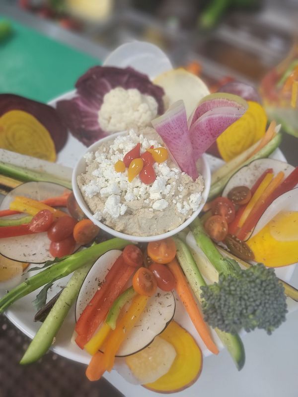 Vegetable platter with dip: colorful sliced vegetables, cherry tomatoes, and a central dip bowl.