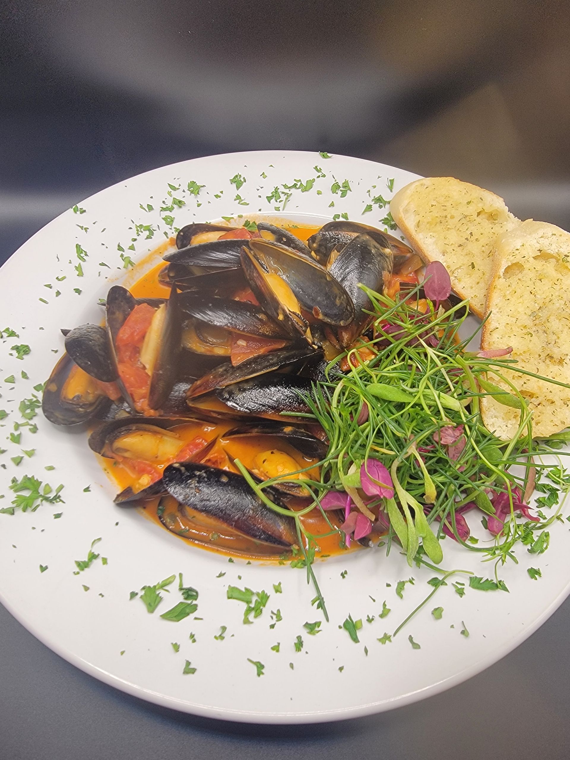 a plate of Spanish style Mussels in a tomato creamy sauce