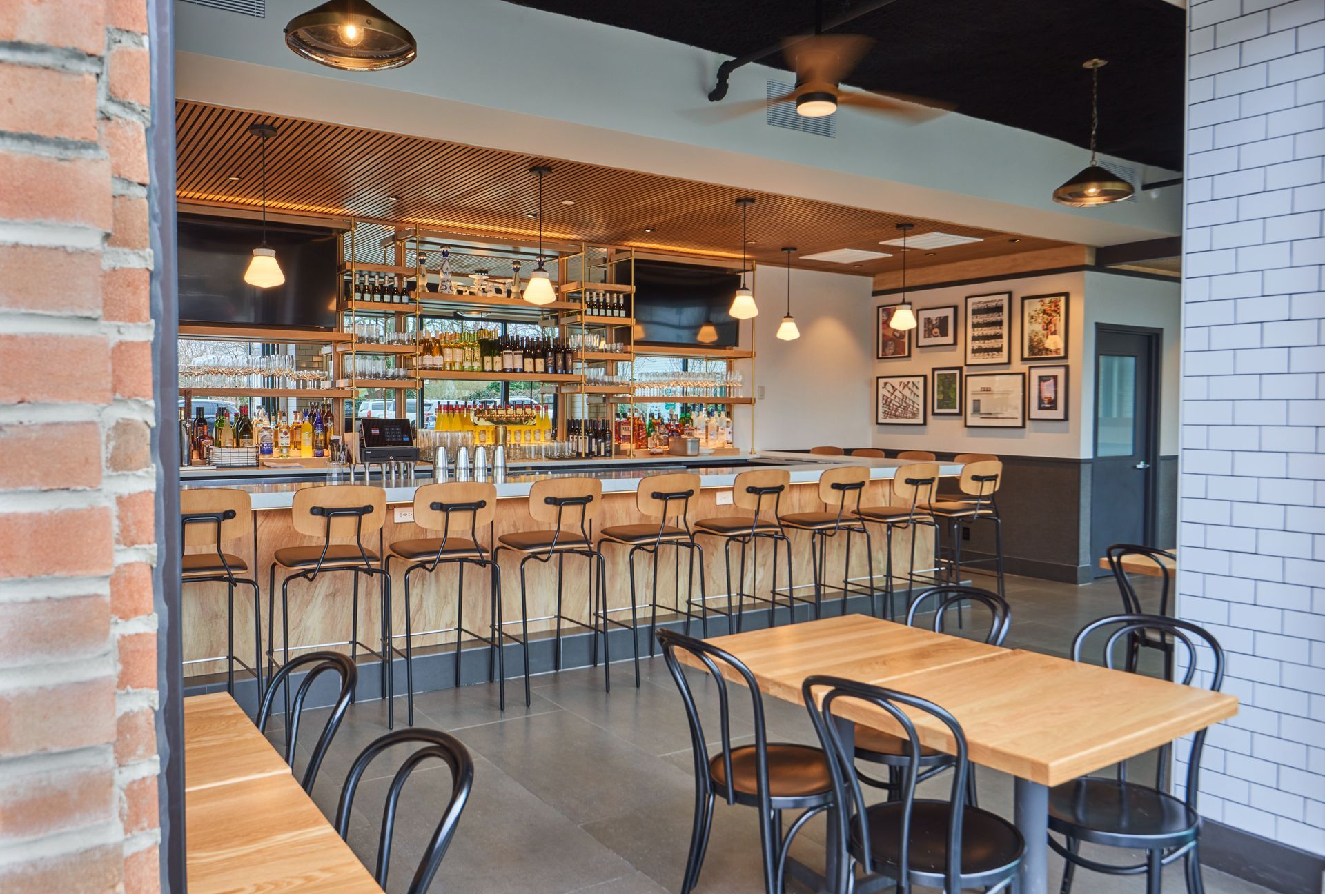 A restaurant with tables and chairs and a bar.