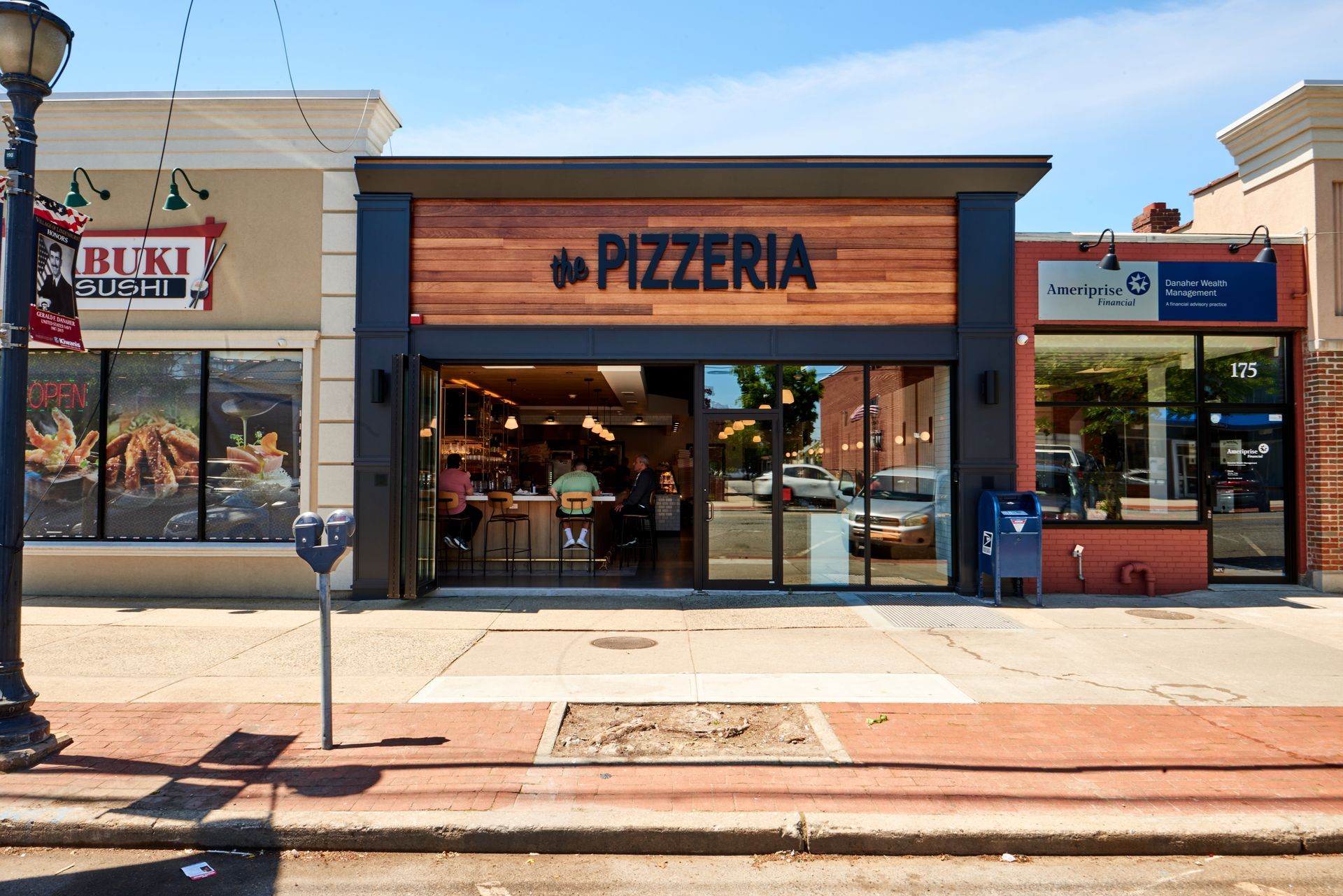 The pizzeria is located on the corner of a city street