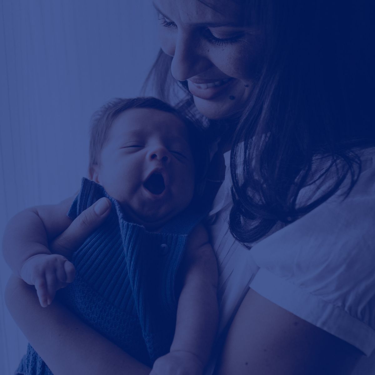 A woman is holding a baby in her arms.