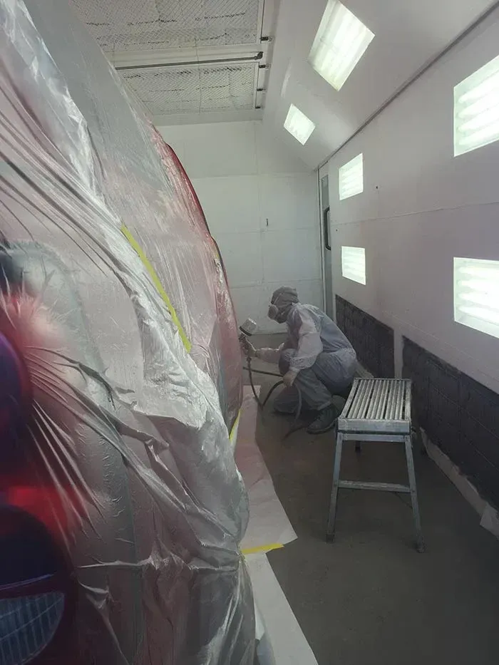 A Man Is Painting A Car — Santa Rosa, CA — Precision Frame and Body Shop