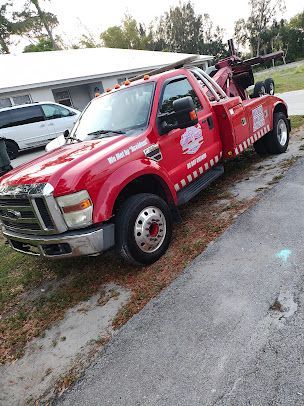 A red tow truck is parked on the side of the road.