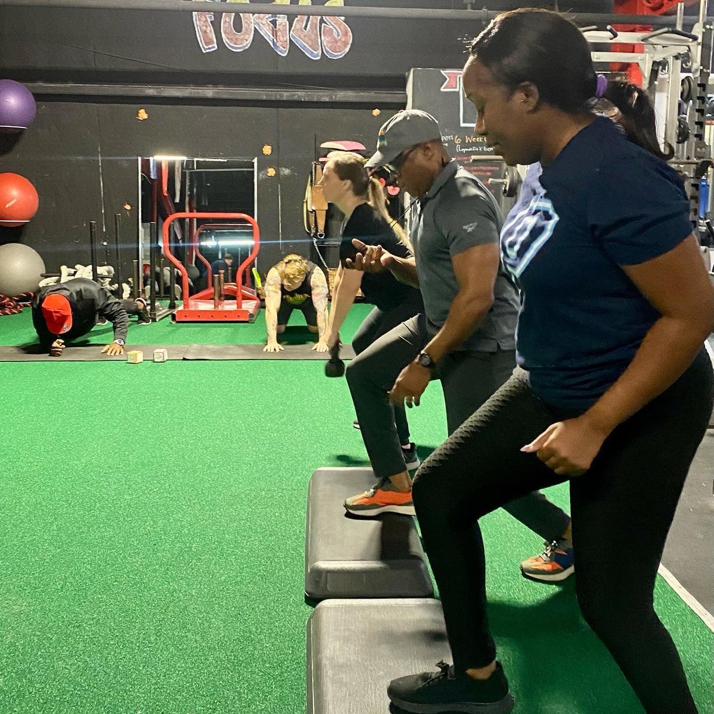 A group of people are doing exercises in a gym.