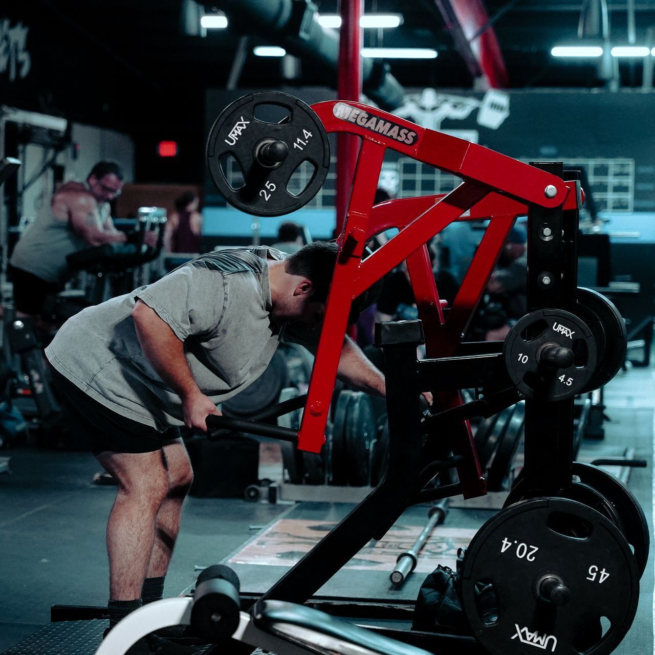 A man is squatting down in front of a machine that says upack on it