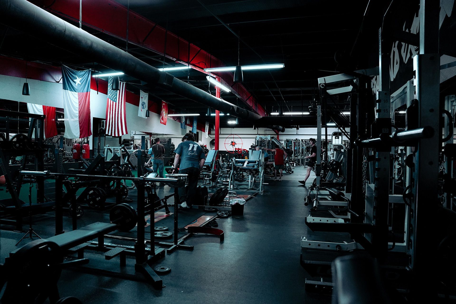 A gym filled with lots of exercise equipment and people.
