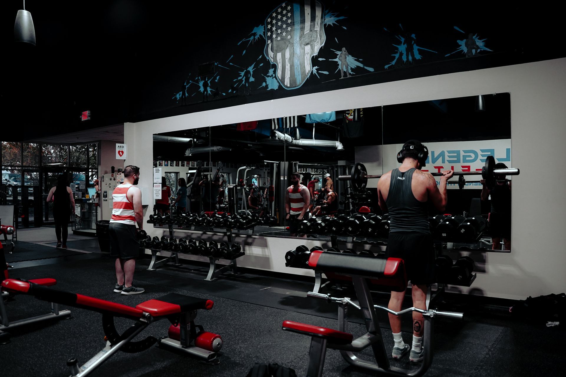 A man is lifting a dumbbell in a gym