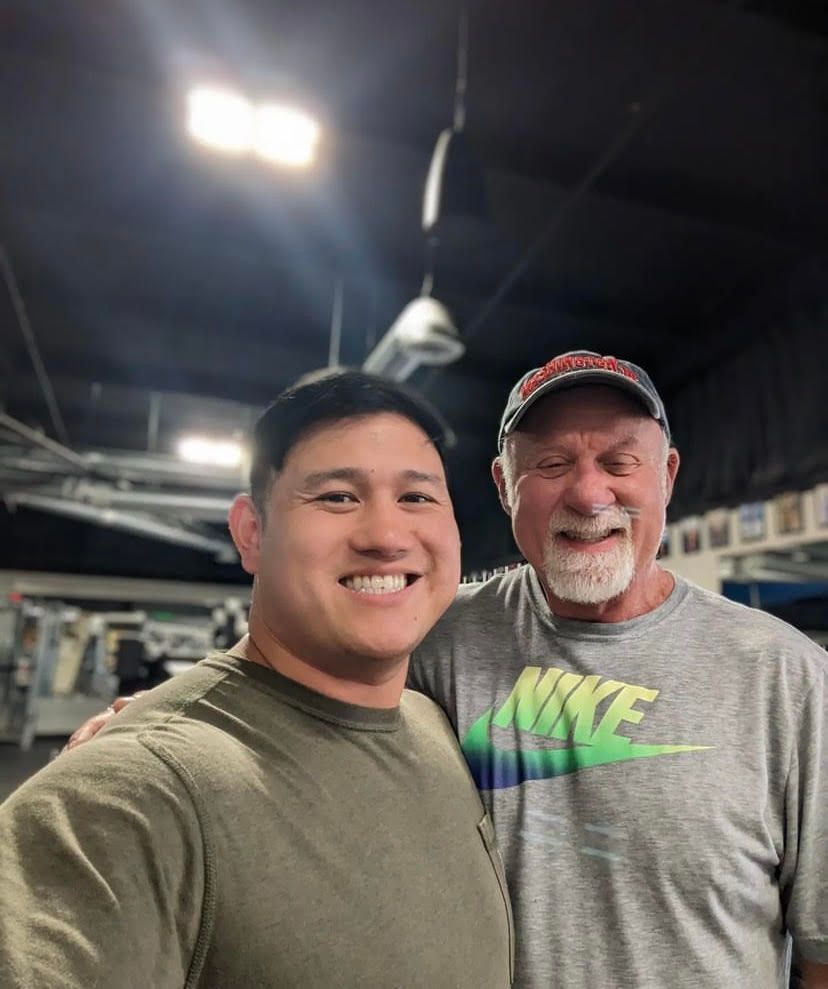 A man wearing a nike shirt is standing next to another man