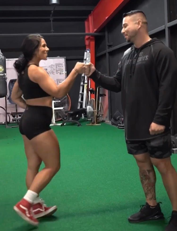 A man and a woman are shaking hands in a gym