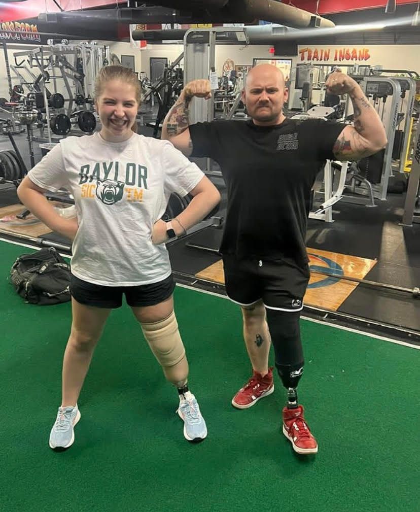 A man and a woman are posing for a picture in a gym.