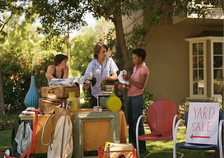 A yard sale is being held in front of a house