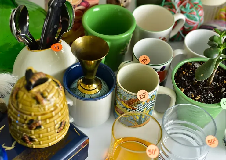 A bunch of mugs and glasses are on a table