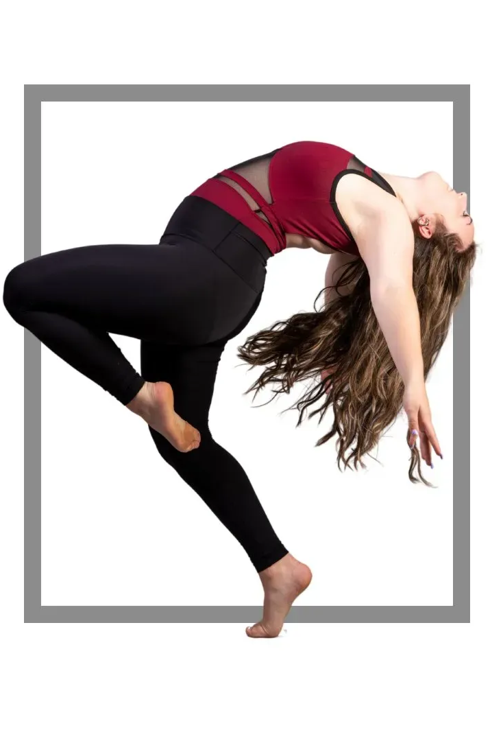 Dancer arches back in mid-air, wearing maroon top and black leggings, long hair flows.
