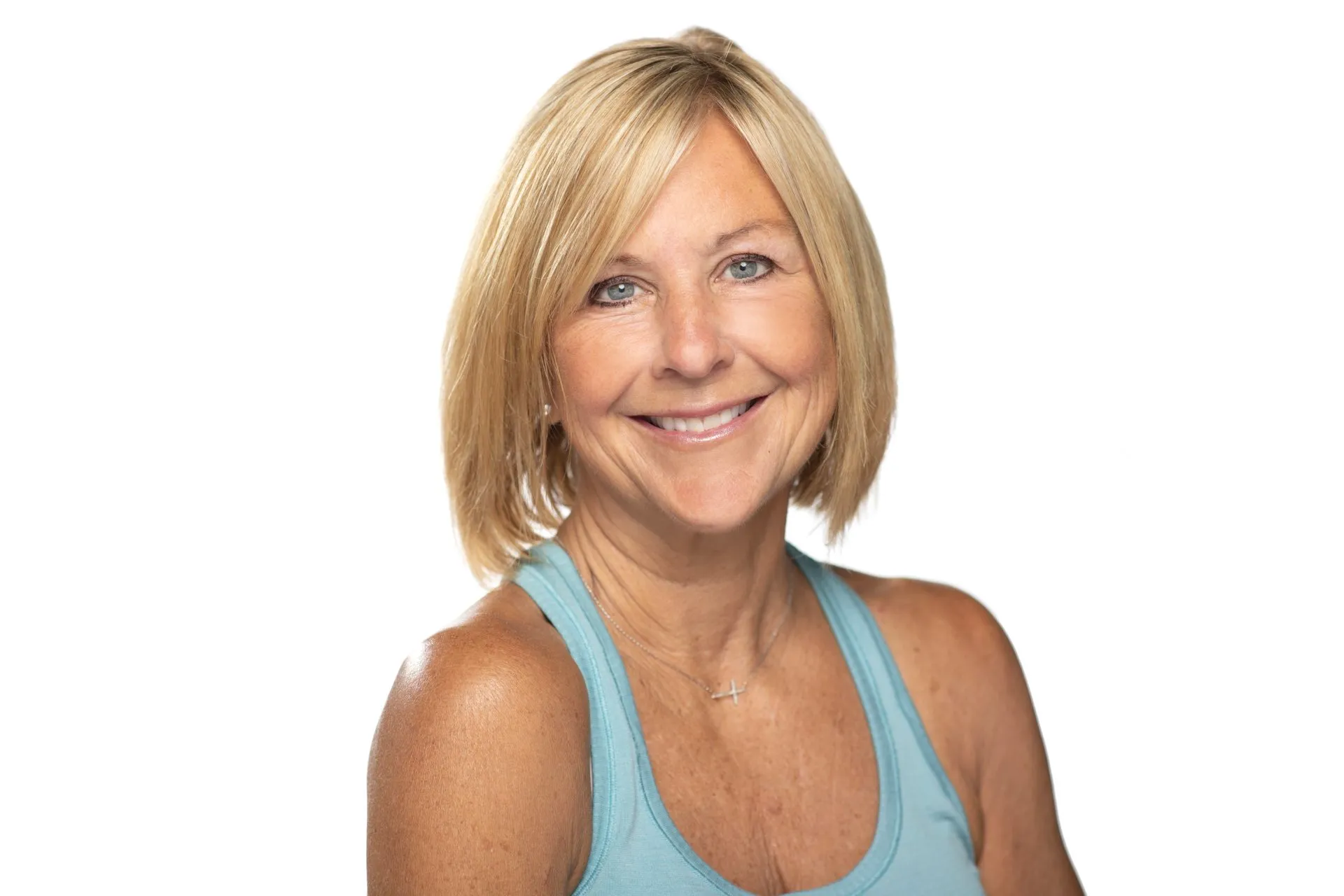 Woman with blonde bob haircut smiles, wearing a turquoise tank top, against a white background.