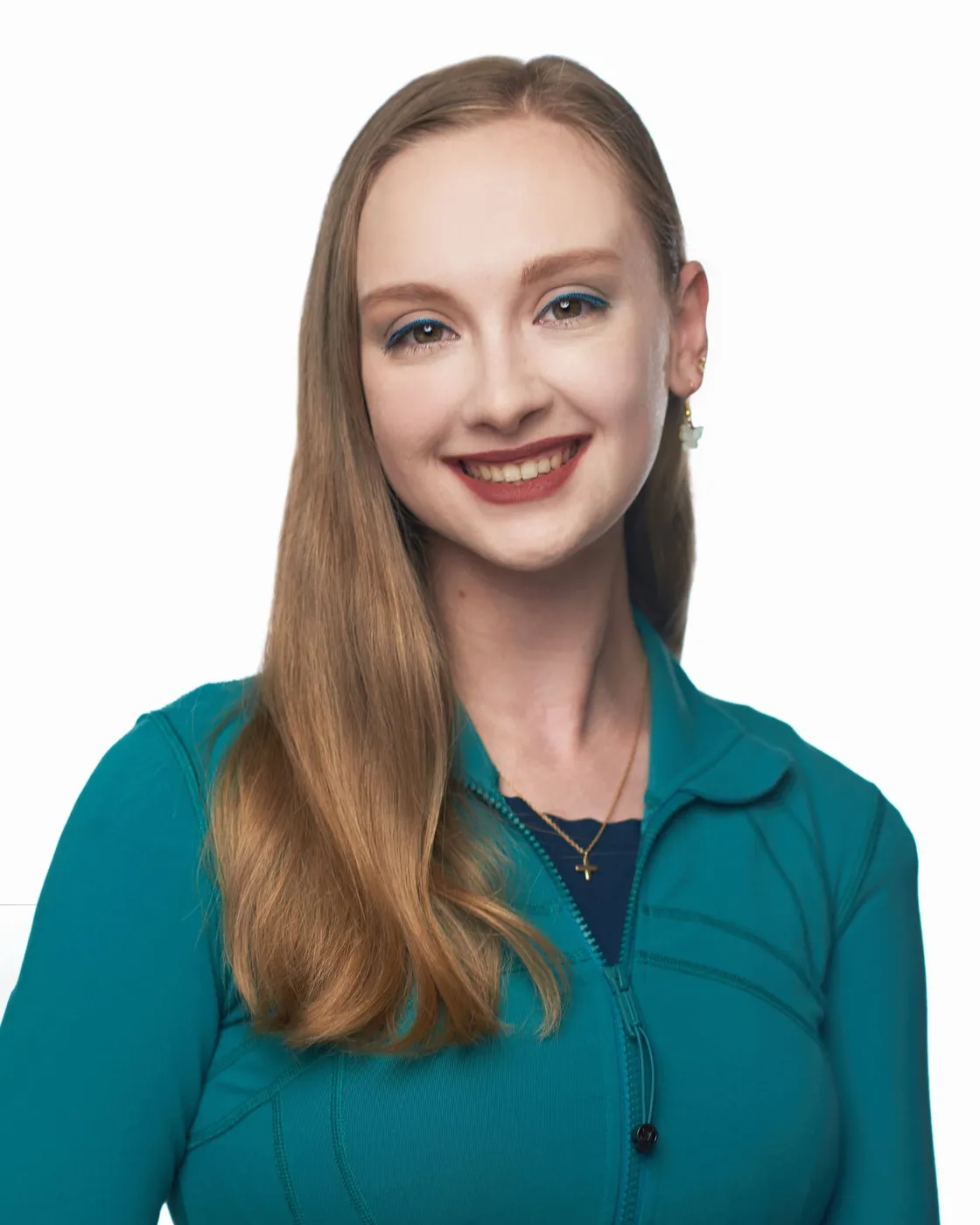 Woman with long blonde hair smiles, wearing a turquoise jacket against a white backdrop.