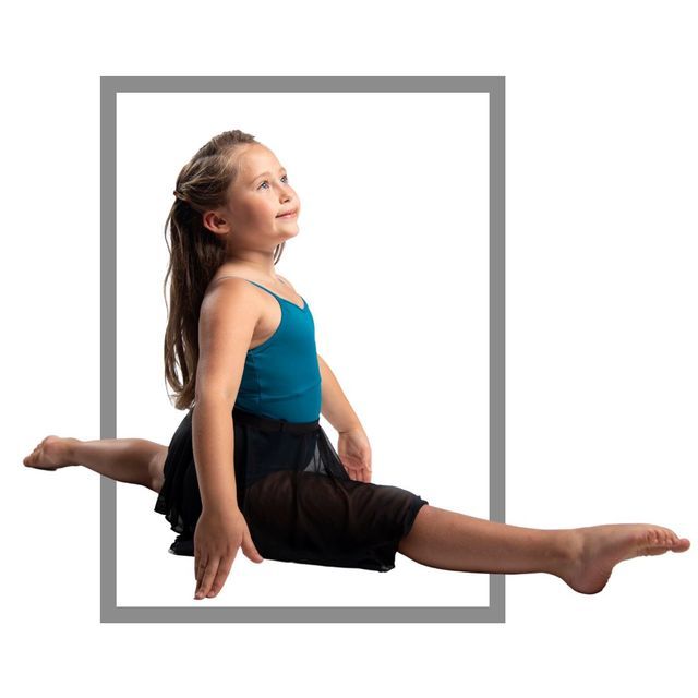 Young girl in teal leotard doing the splits inside a gray rectangular frame, looking upward.