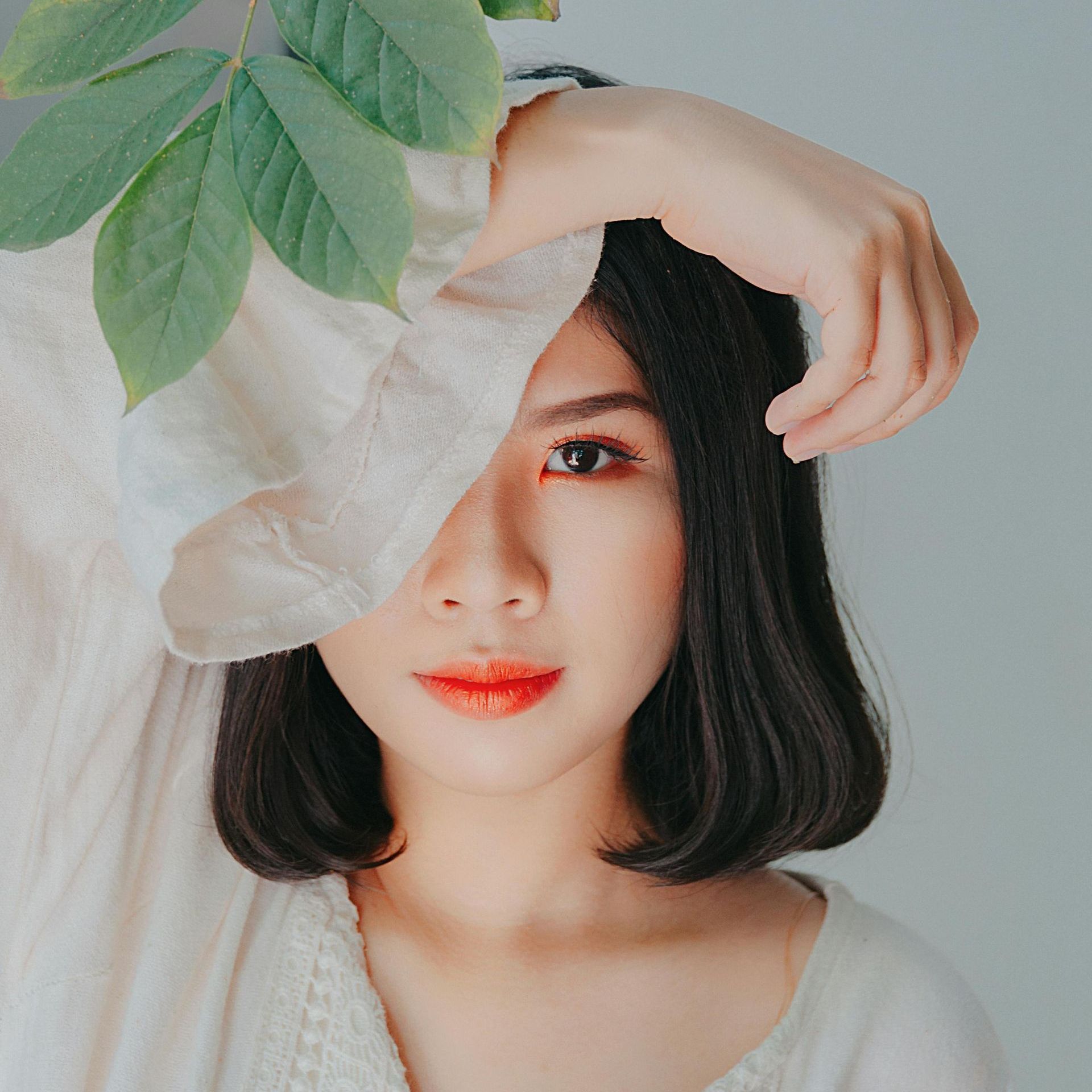 A woman covering her face with a white cloth