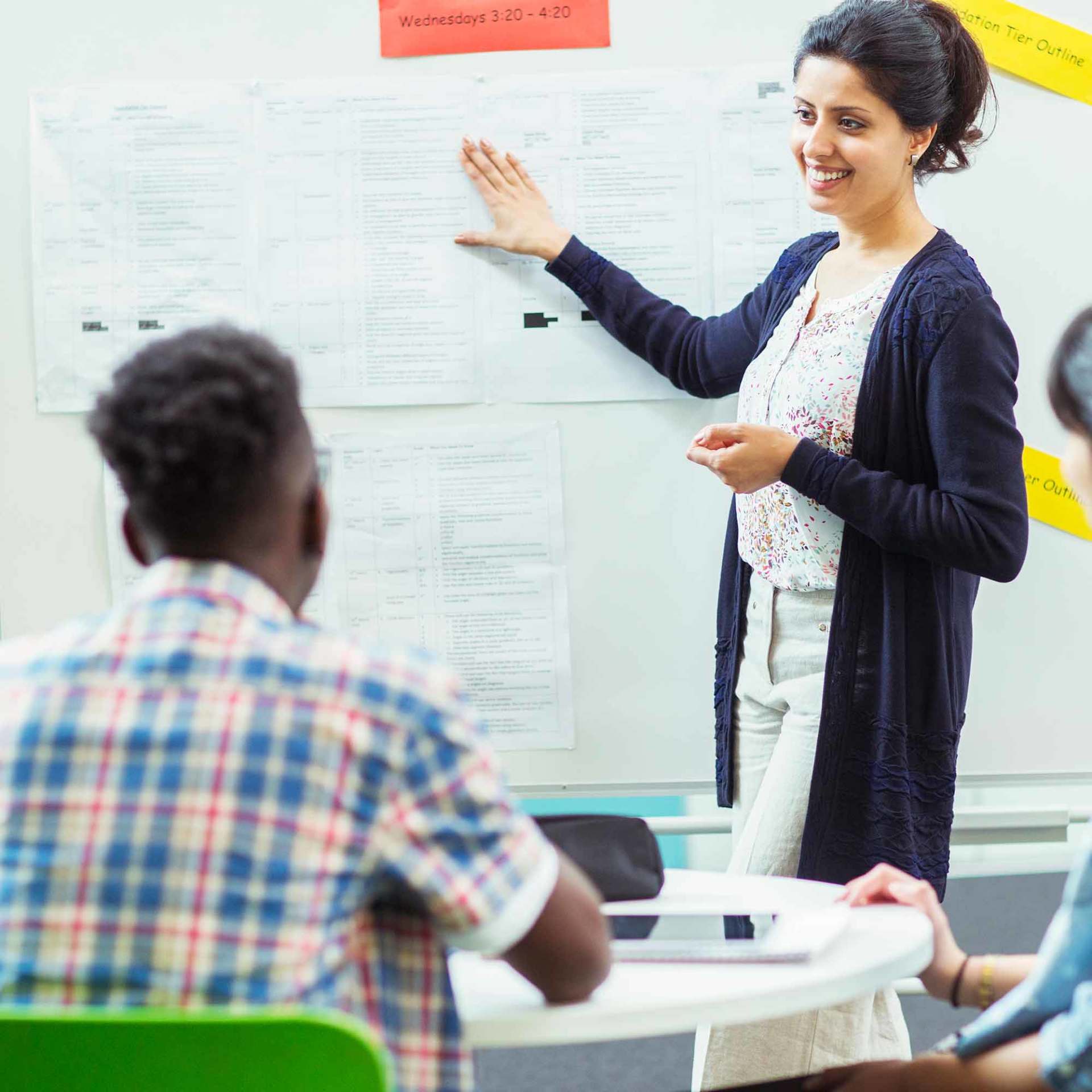 Student looking at teacher showing documents on whiteboard