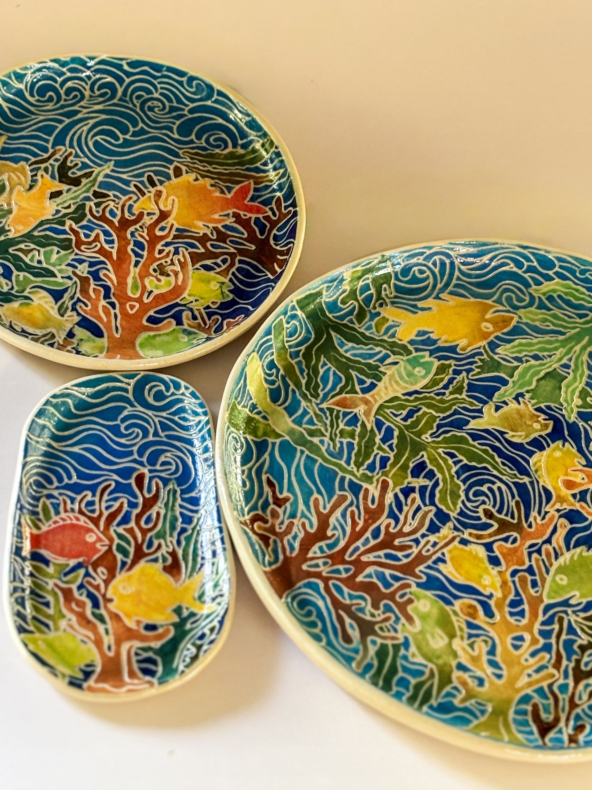 Image of a plate with a colourful underwater scene of coral, seaweed and fish, with flowing blue water.
