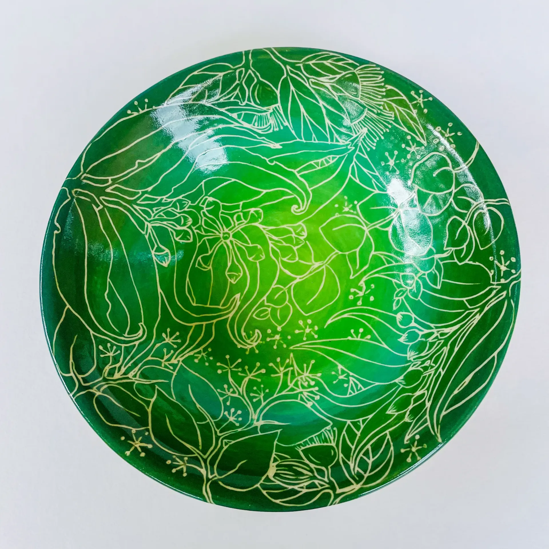 Green glass bowl with gold floral design.