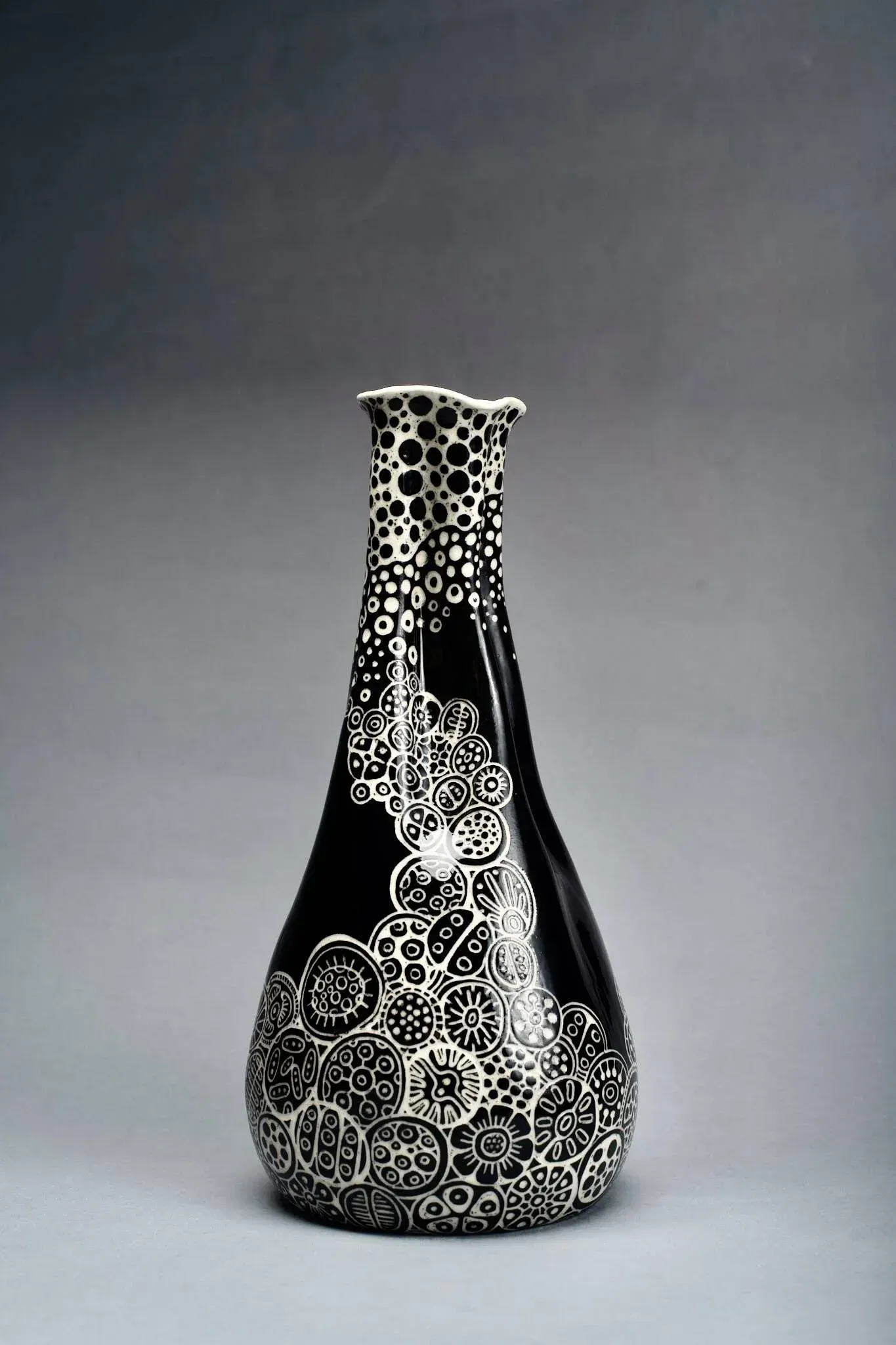 Black vase with white floral patterns.