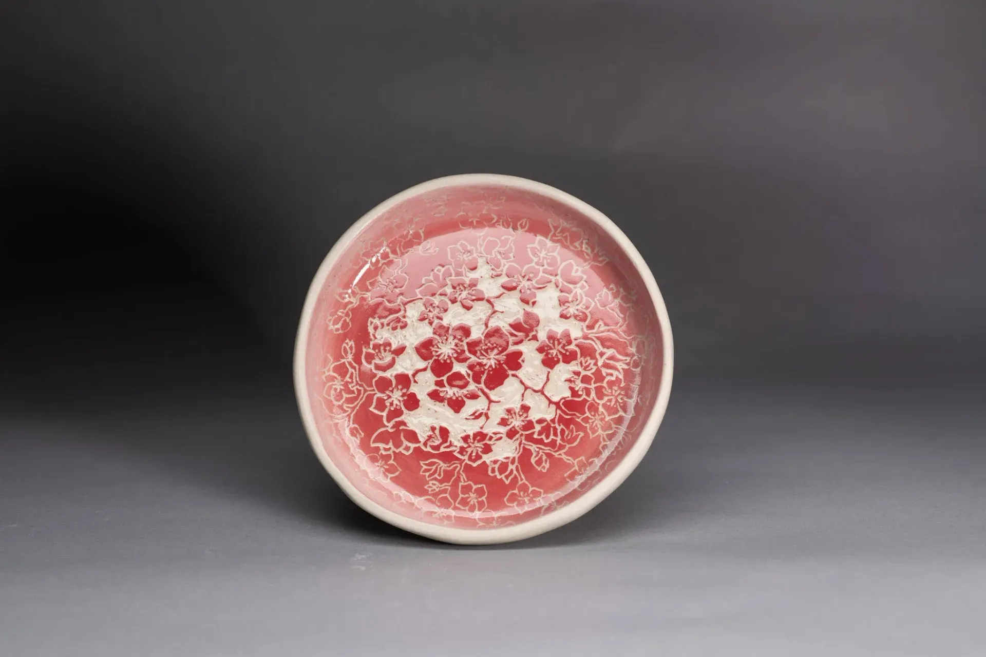 Red and white patterned bowl on a gray surface.