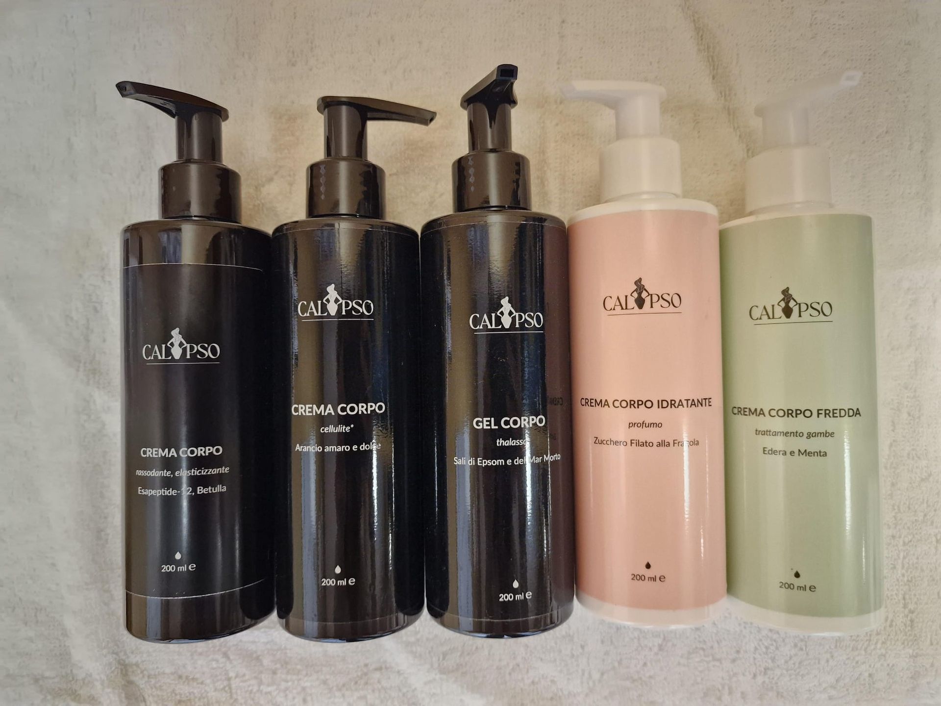 Una fila di bottiglie di diversi tipi di prodotti cosmetici