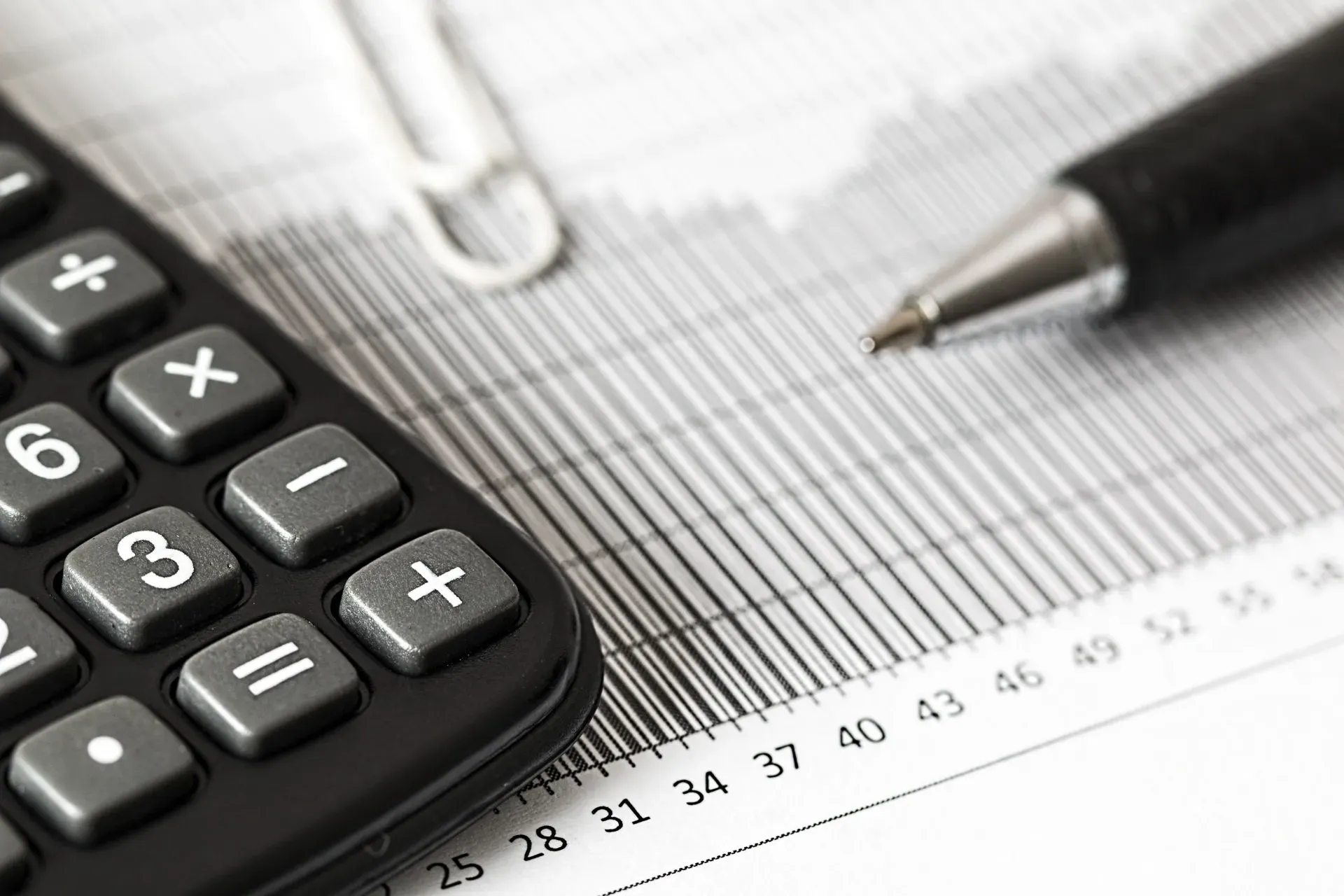 A pen is sitting next to a calculator on a graph