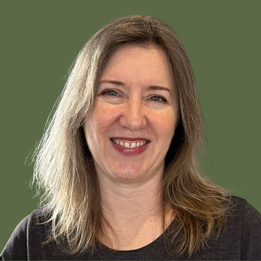 A woman with long hair is smiling and wearing a black shirt.