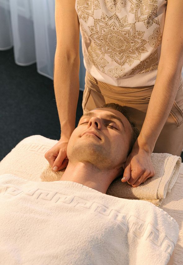 A man is laying on a table getting a massage from a woman.