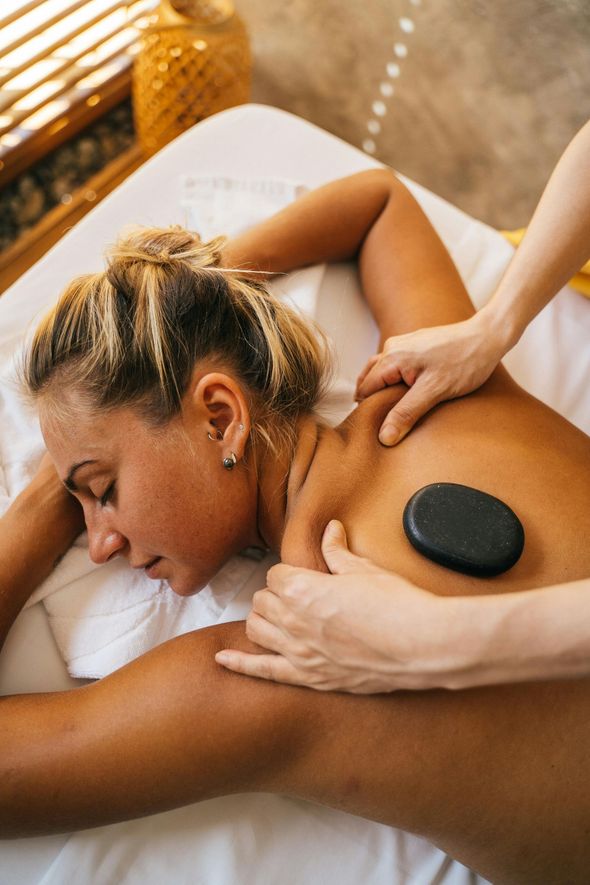 A woman is getting a hot stone massage at a spa.