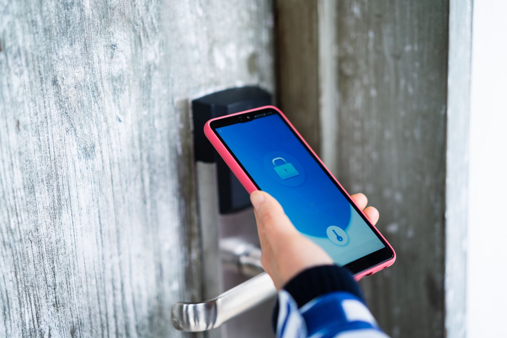 Una persona sta usando uno smartphone per aprire una porta.