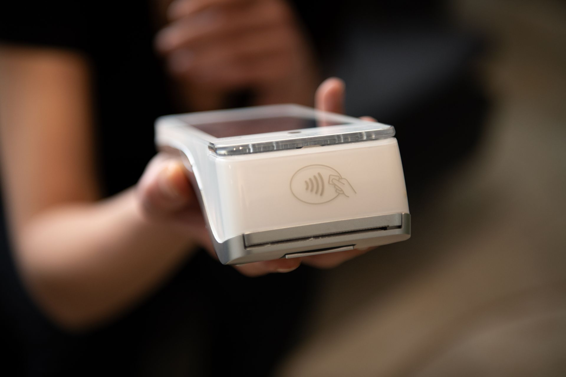 Una persona tiene in mano un lettore di carte di credito.