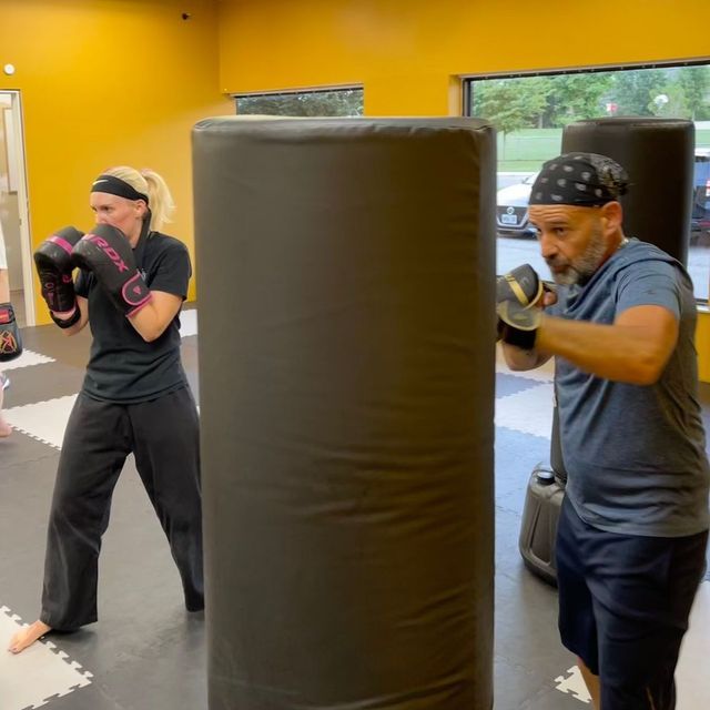 A man and a woman are boxing in a gym