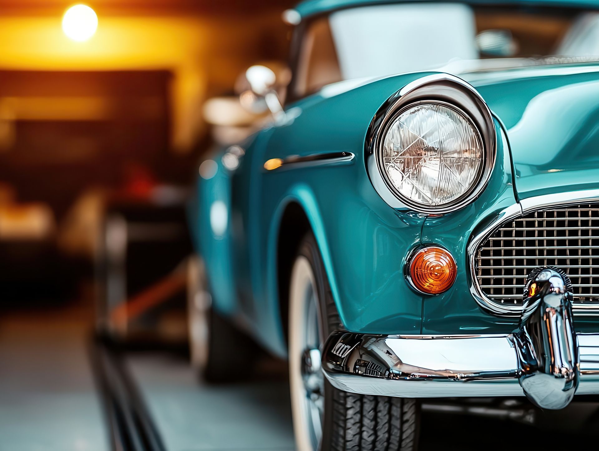Mechanic inspecting a blue car on a tow truck, outdoors.