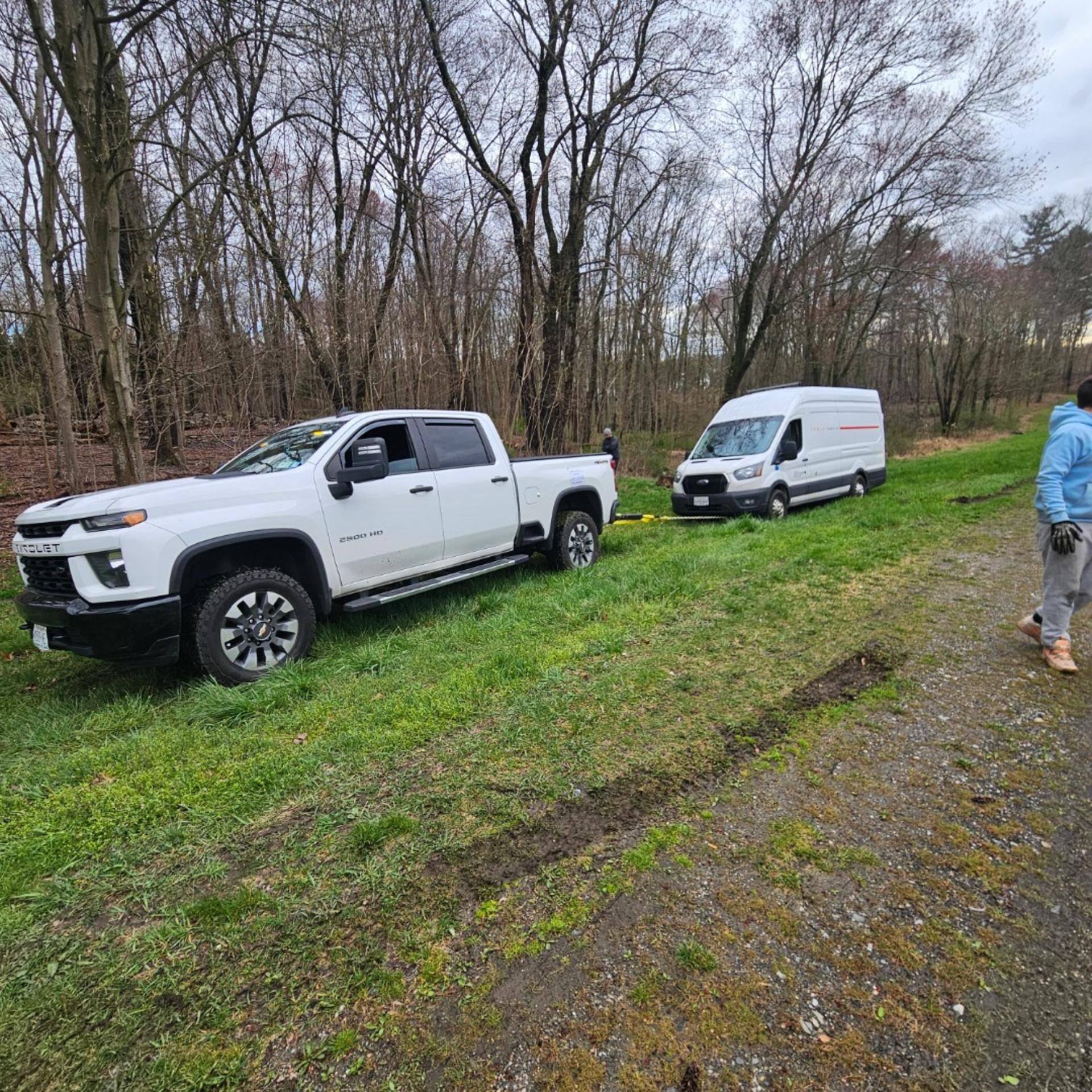 Damaged gray car on a tow truck on a city street.
