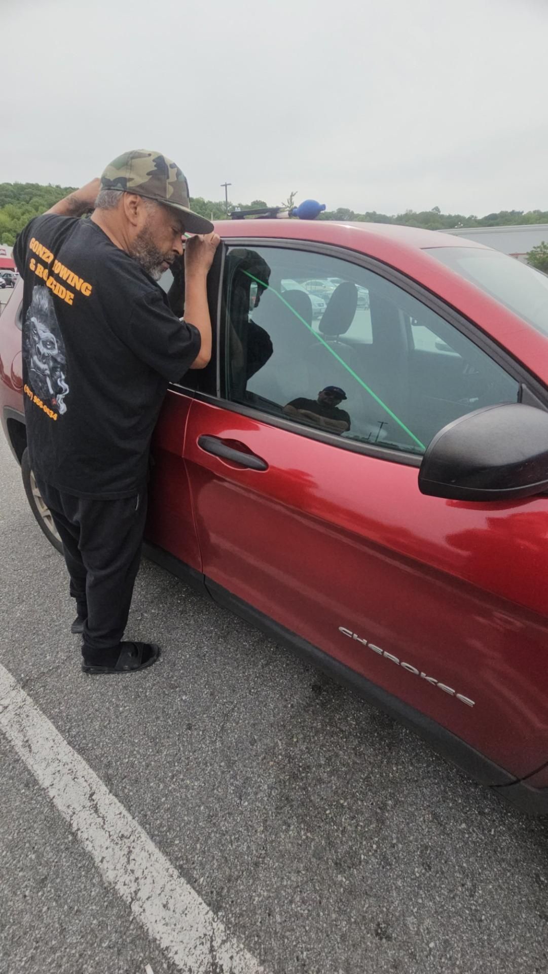 Interior car door with handle and window controls; dashboard visible.
