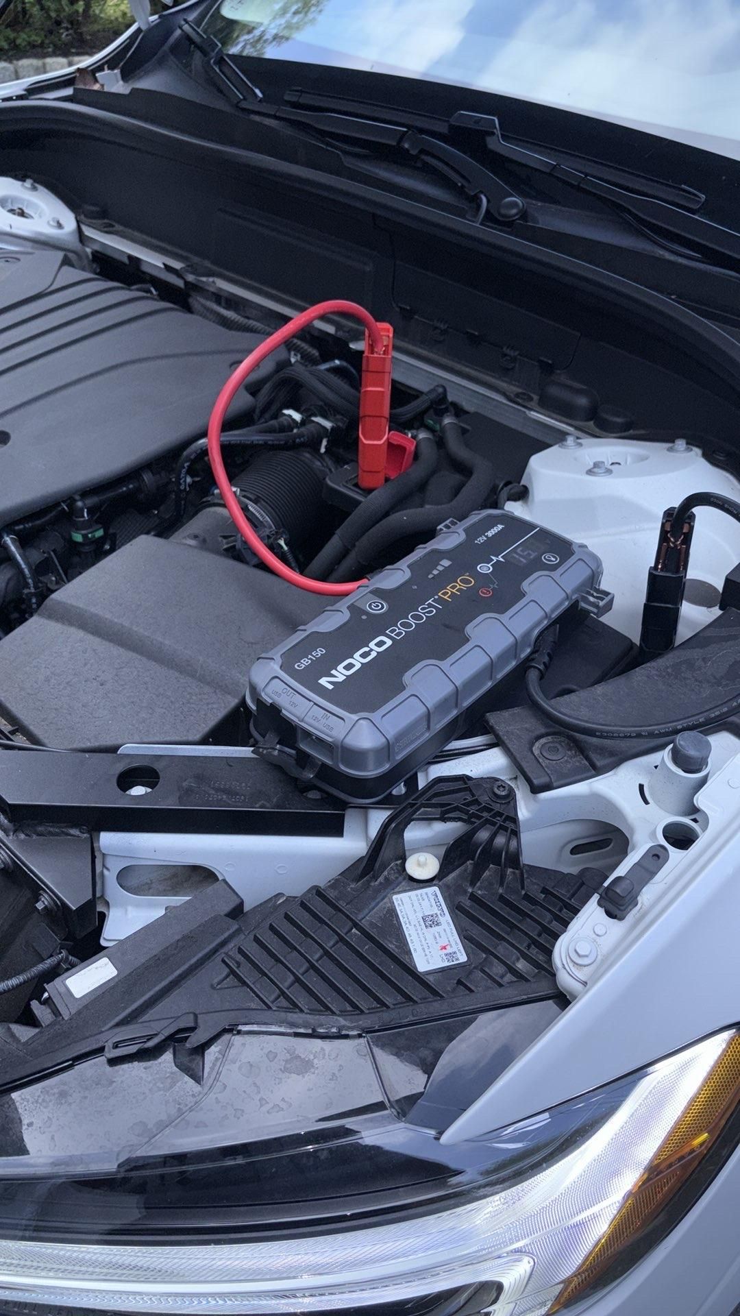 Mechanic replacing a car battery with a wrench. Outdoors.