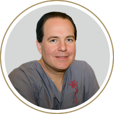 A smiling doctor in a lab coat with a stethoscope around his neck.