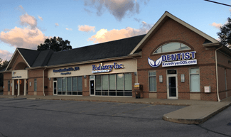 Exterior of a brick building with multiple businesses, including a dentist's office.