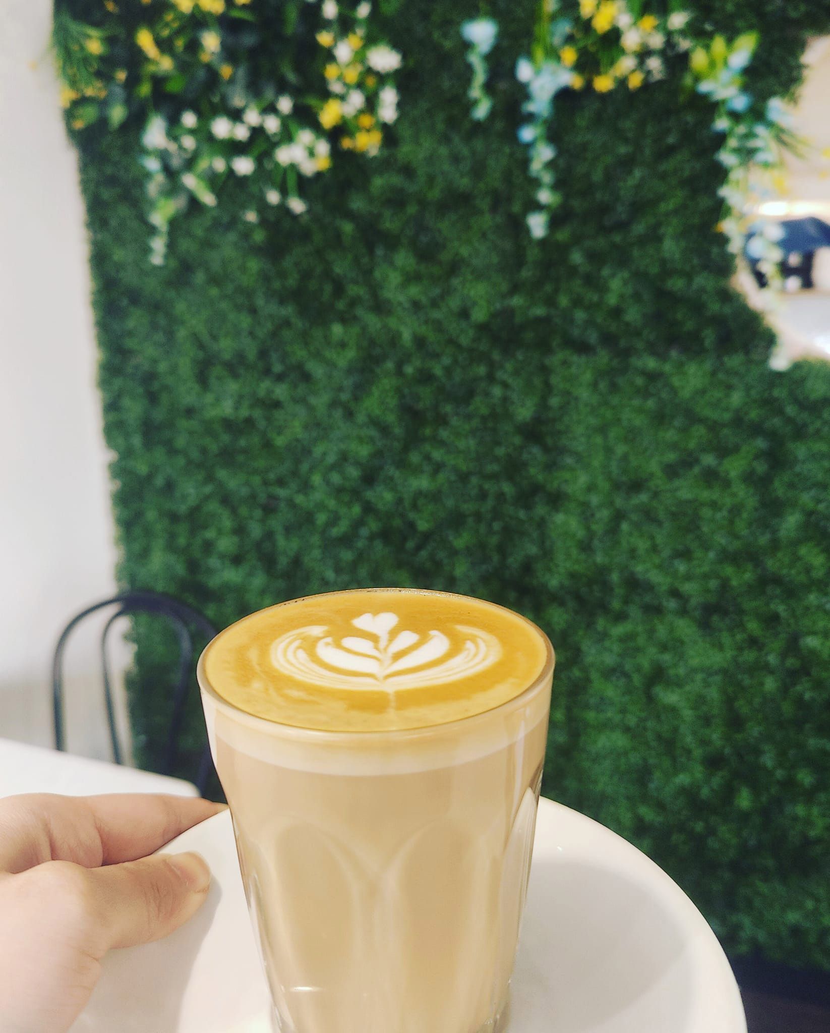 a person is holding a cup of coffee on a table