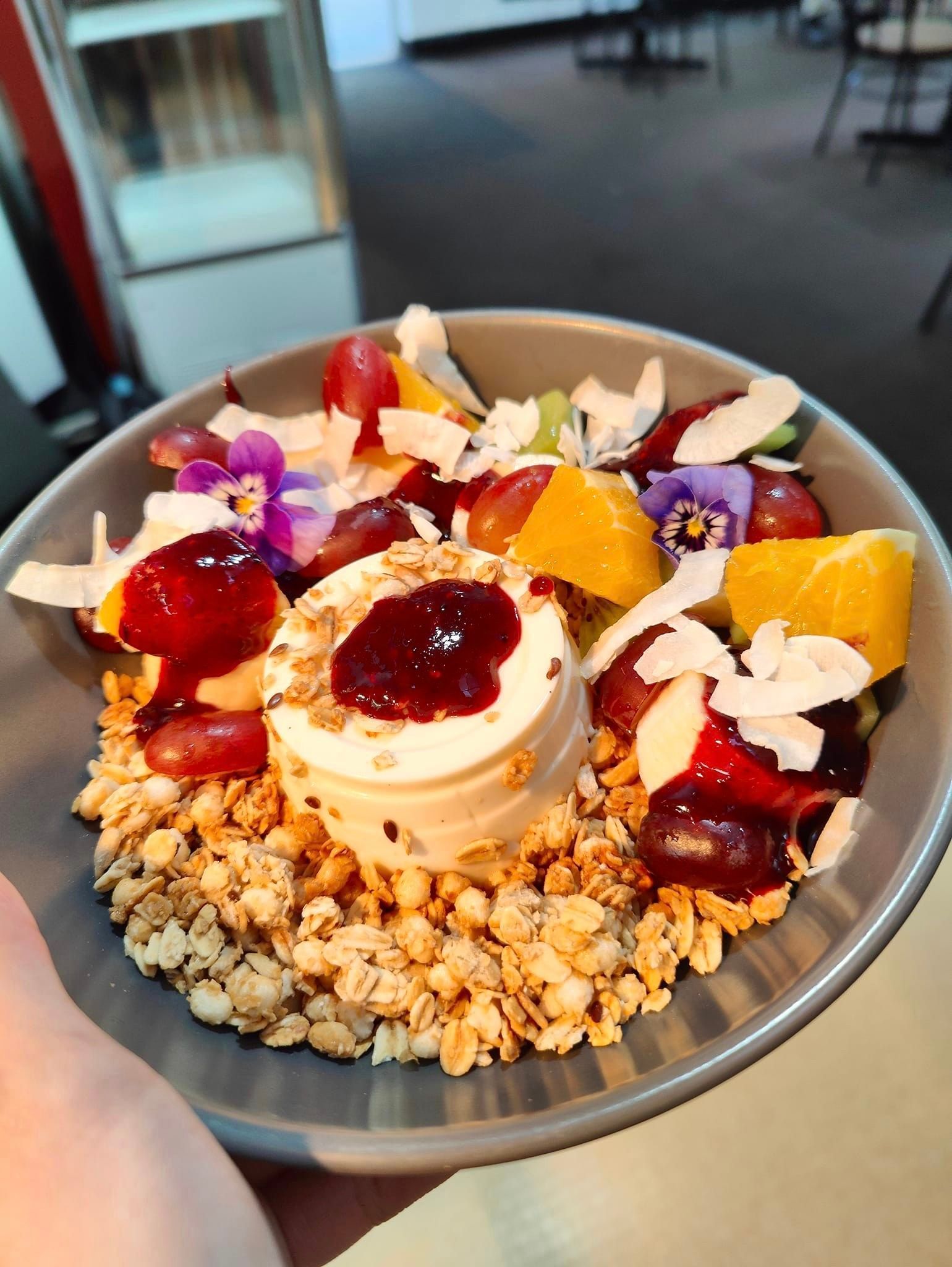 a bowl of granola with fruit and ice cream on top