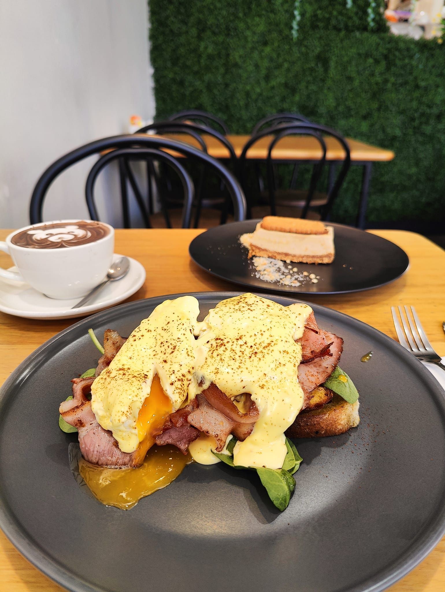 a plate of food is sitting on a table next to a cup of coffee .