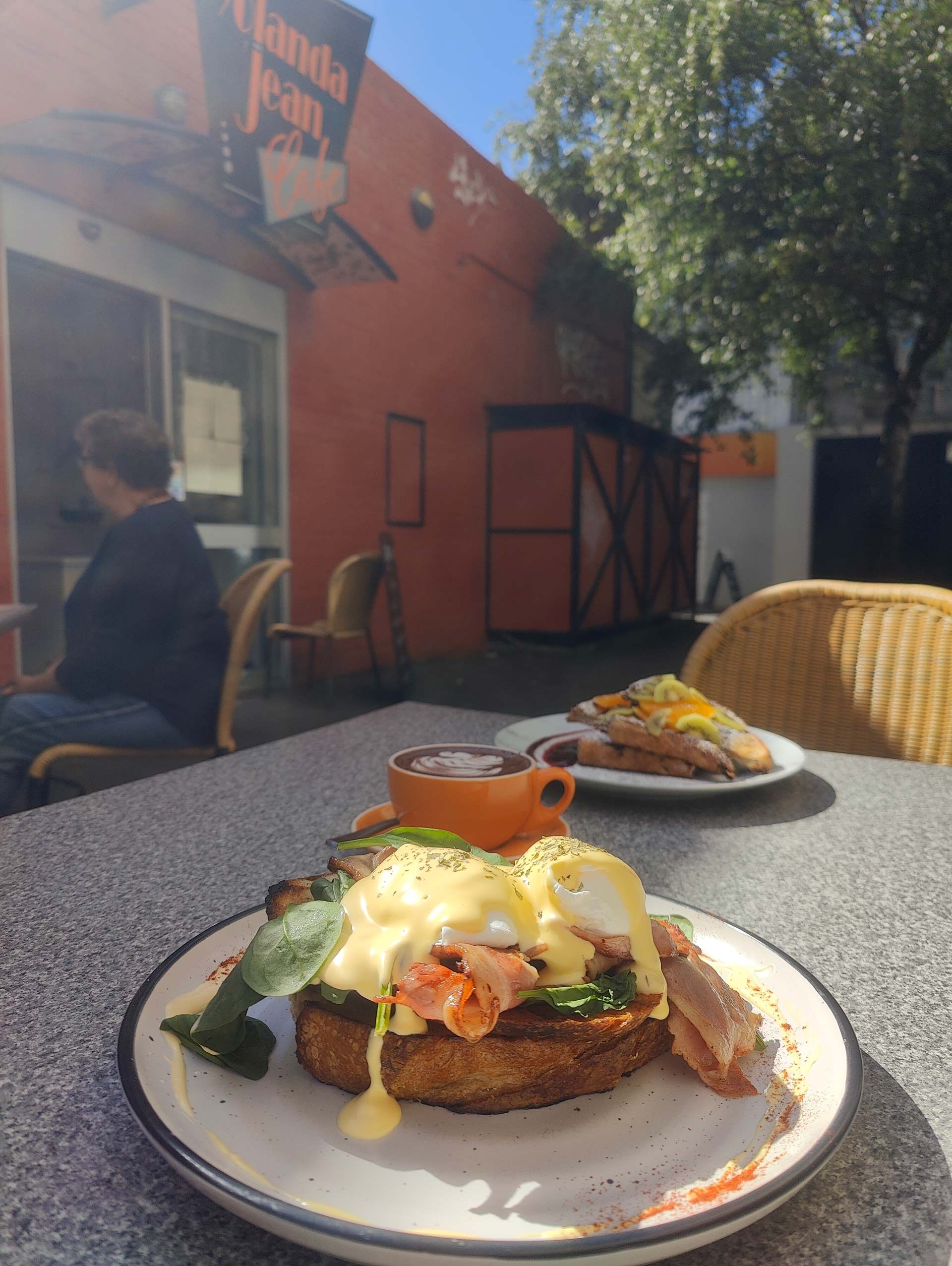 a plate of food sits on a table outside of a restaurant