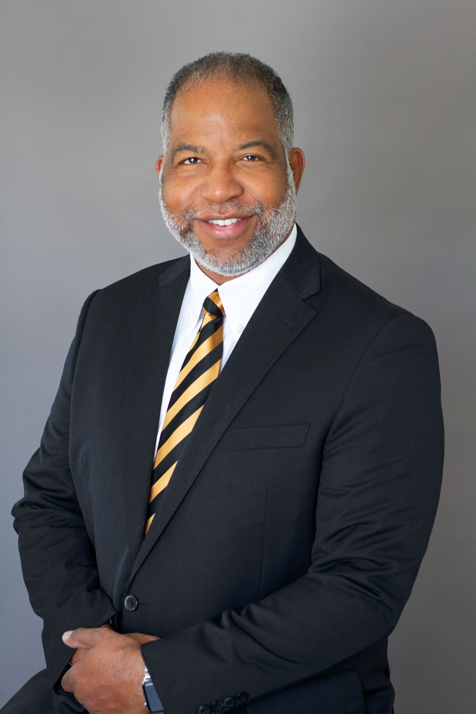 A man in a suit and tie is smiling for the camera.
