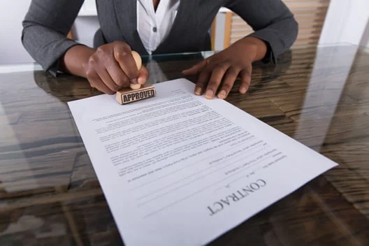 A woman is stamping a contract on a glass table.