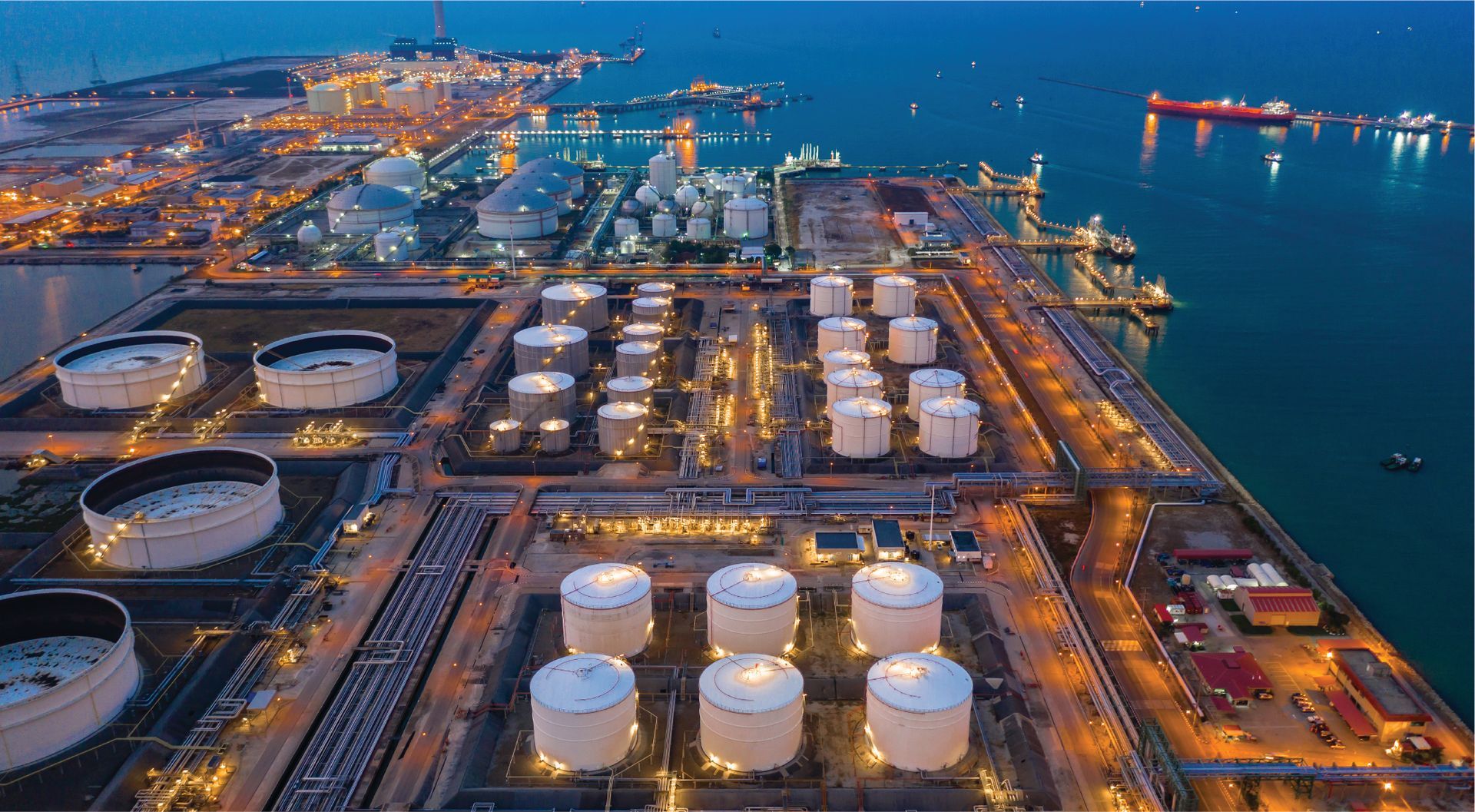 Refinery on the coast with storage tanks in low light